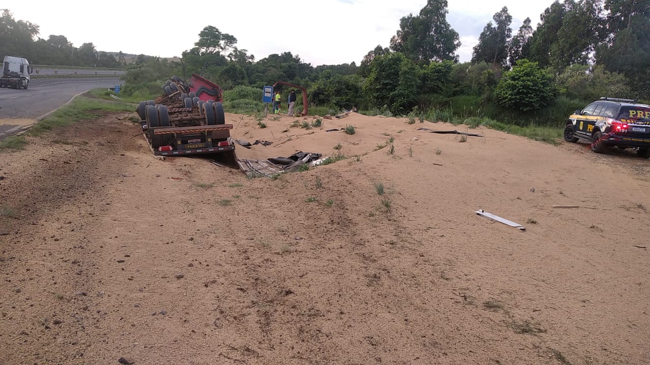 Caminhão tomba às margens de pista e carga de soja se espalha